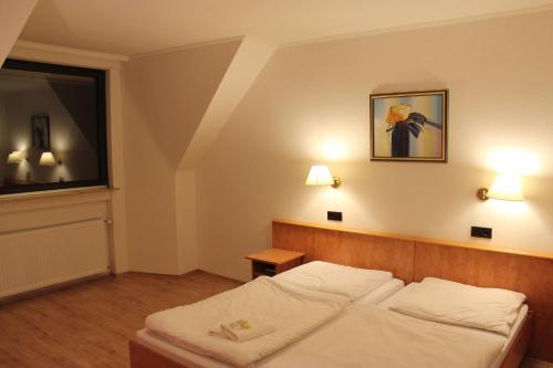 a bedroom with a white bed in a room at Hotel Gaya in Bad Soden am Taunus