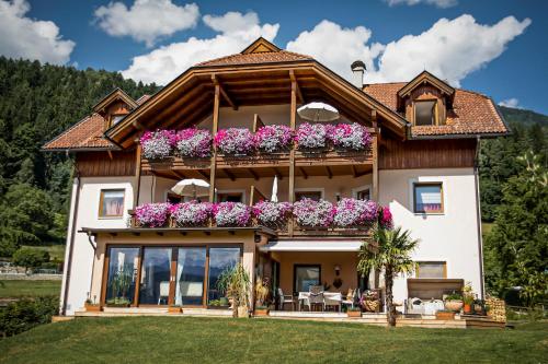 a house with a balcony with flowers on it at Ferienwohnungen Seerose in Dellach direkt am Millstätter See in Millstatt