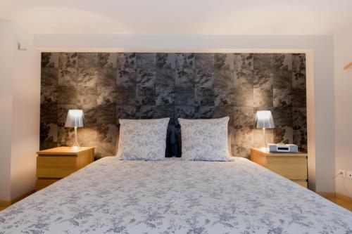 a bedroom with a large bed with two lamps at La Noctambulle Cathédrale in Reims