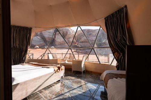 Pokój z 2 łóżkami i dużym oknem w obiekcie experience staying camp.wadi rum w mieście Disah
