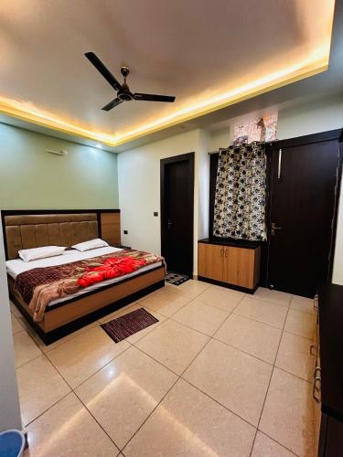 a bedroom with a bed and a ceiling fan at Saraswati Dhaam in Vrindāvan