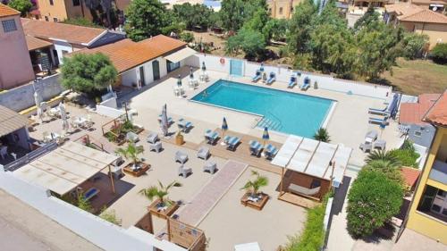 an overhead view of a large swimming pool with lounge chairs at Le Palme Holidays in Palmadula