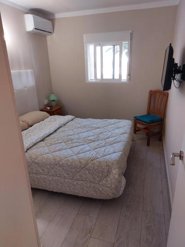 a bedroom with a bed and a window and a chair at Casa Giulia in Denia