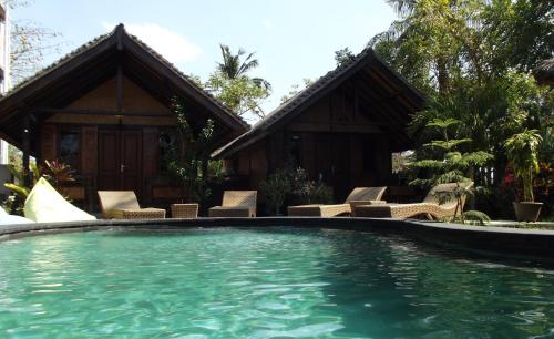 a swimming pool in front of a house at Gili Flush Harmony in Gili Trawangan