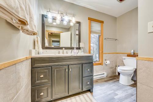 uma casa de banho com um lavatório, um espelho e um WC. em Pristine Resort Townhome 2 Mi to Seven Springs Mtn em Champion