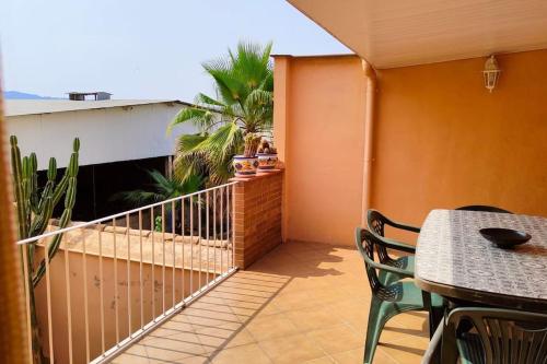 a balcony with a table and chairs and palm trees at Casa Bretalunya in Benissanet