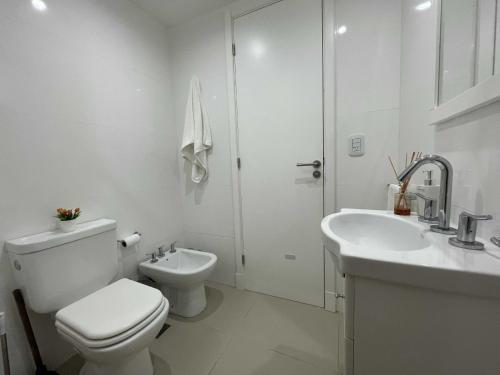 a white bathroom with a toilet and a sink at Depto Estela - Monoambiente Zona Macrocentro para 2 PAX - Hola Sur in Mar del Plata