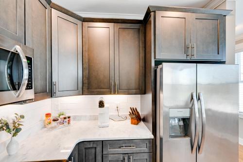 a kitchen with wooden cabinets and a stainless steel refrigerator at Modern Nashville Condo Walk to Local Breweries! in Nashville