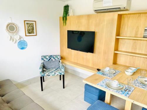 a living room with a table and a tv at Apartamento a 100 m da praia in Juquei