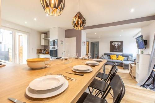 une salle à manger et un salon avec une table et des chaises dans l'établissement Maison tout équipée Châteaugay Terrasse & Garage, à Châteaugay