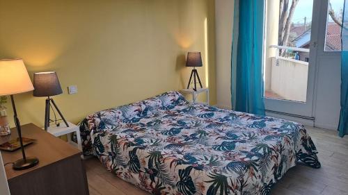 a bedroom with a bed and a table and a window at Appart T3 central calme proche Thermes pour cures/vacances in Saint-Paul-lès-Dax