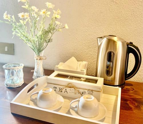 a tray with two cups and a tea kettle on a table at country house in Ardea