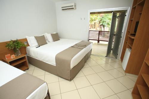 a bedroom with a bed and a sliding glass door at Hotel Sesi Aruana in Aruanã