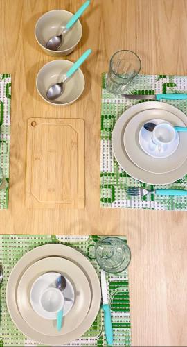 a table with plates and spoons on top of it at Apartamento a 100 m da praia in Juquei