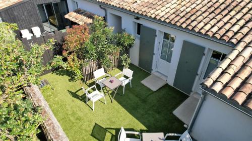 an overhead view of a backyard with chairs and a table at L'Ile sous le Vent in Sainte-Marie-de-Ré