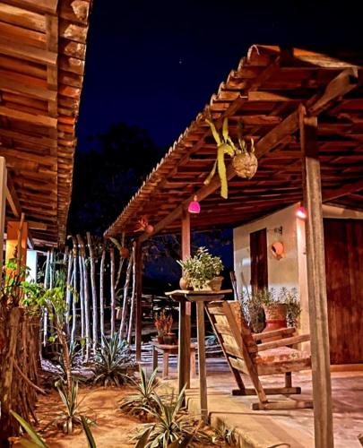 a wooden pergola with a table and some plants at Pousada Fulô da Pedra in Serra de São Bento