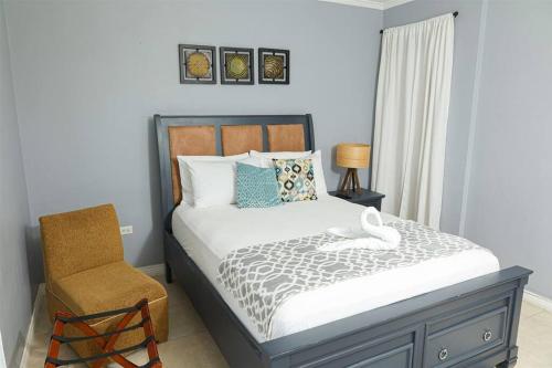 a bedroom with a bed and a chair at Journey`s End with Prohomesja at Bromptons in Kingston
