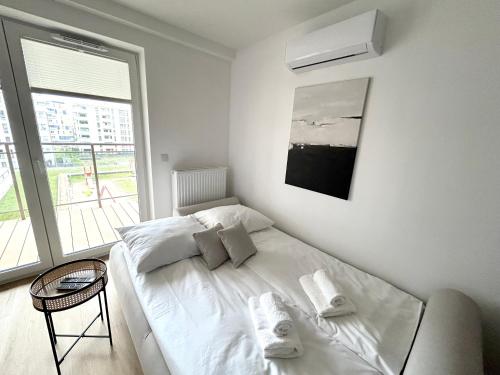 a white bed in a room with a window at Apartament Lina Koralowa in Lublin