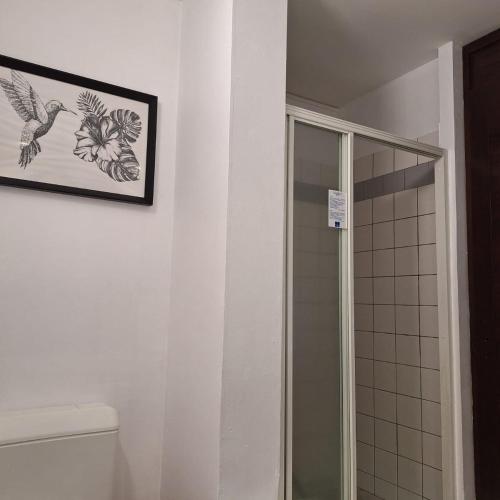 a bathroom with a shower and a picture on the wall at 135_ananas_bdg in La Trinité