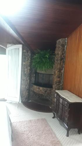 a room with a stone wall with a potted plant at Chalés do Cachoeirão in Visconde De Maua