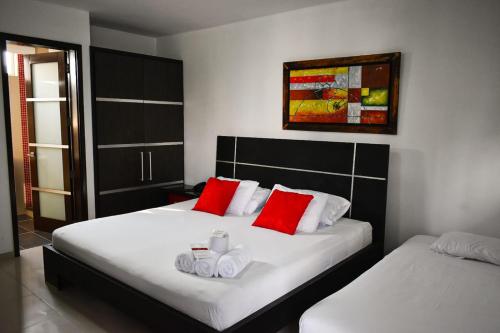 a bedroom with two beds with red pillows at Hotel Or Cartagena in Cartagena de Indias