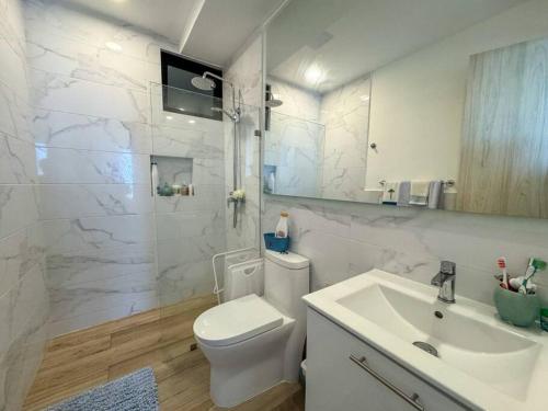 uma casa de banho branca com um WC e um lavatório em Paraíso Privado en Punta Cana em Punta Cana