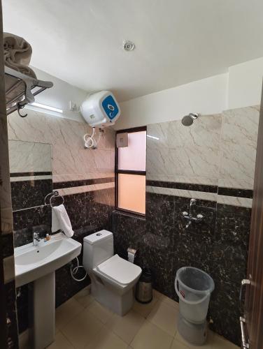 a bathroom with a white toilet and a sink at The Grand ND Resort- Kanha Tulsi Heights Behind Prem Mandir in Vrindāvan