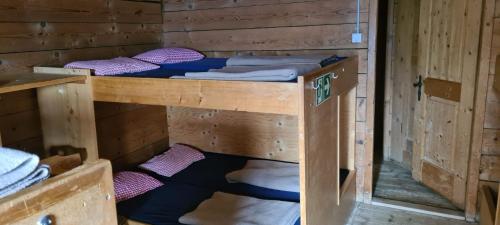 een paar stapelbedden in een houten kamer bij Skihaus Hochwang in Arosa