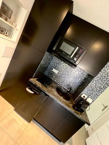 une cuisine avec un comptoir noir avec un micro-ondes dans l'établissement Antibes - 4 People - Swimming pool Tennis Park Parking, à Antibes