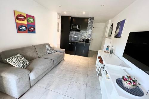 un salon avec un canapé et une table dans l'établissement Antibes - 4 People - Swimming pool Tennis Park Parking, à Antibes