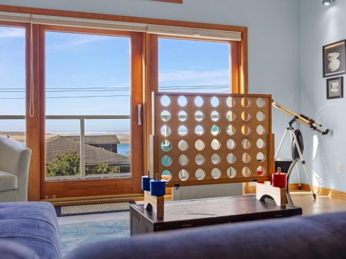 a living room with a couch and a large window at Shoreline Solace: Ocean View Townhouse Tillamook in Tillamook