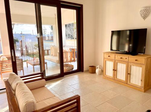 a living room with a flat screen tv on a wooden cabinet at Villa Afrodite in San Pietro in Bevagna