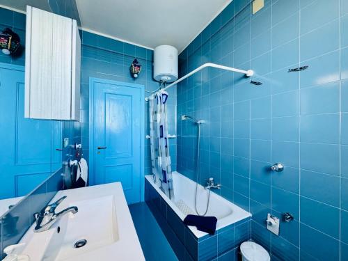 a blue bathroom with a sink and a toilet at YourHome - Dimora di Mare in Amalfi