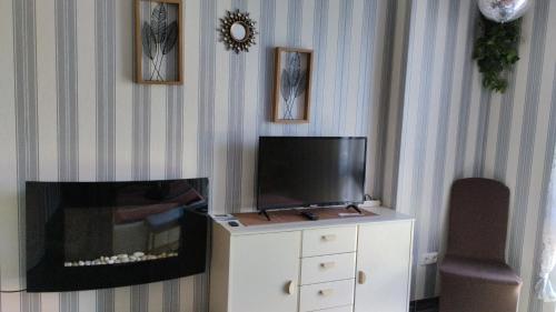 a living room with a tv on a dresser with a fireplace at ruhiger als im Hotel in Merkendorf