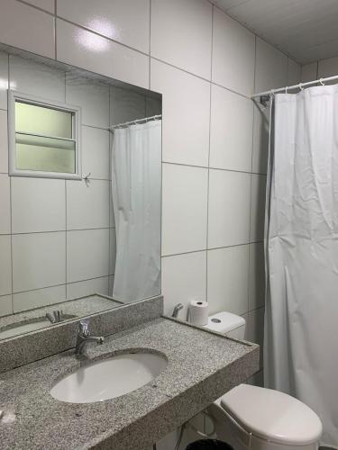 a bathroom with a sink and a toilet and a mirror at Hotel Centro Fashion in Fortaleza