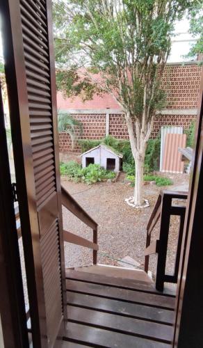 an open door to a yard with a tree at Casa Completa Ótima Localização Vale dos Vinhedos in Bento Gonçalves