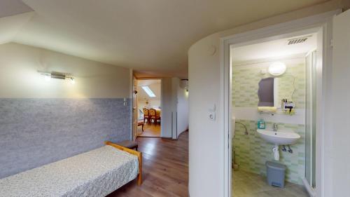 sypialnia z łóżkiem i umywalką w obiekcie Herczeg Apartment w Miskolc-Tapolca