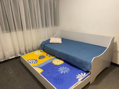 ein Schlafzimmer mit einem Bett mit einer blauen und gelben Decke in der Unterkunft Departamento 3 camas Centrico / Vista in Quito