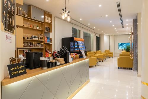a lobby of a store with yellow chairs and a counter at AlNakheelPark Serviced Apartment Economy in Riyadh