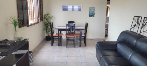 Recanto do mar e da lagoa في أرايال دو كابو: غرفة معيشة مع أريكة وطاولة وكراسي