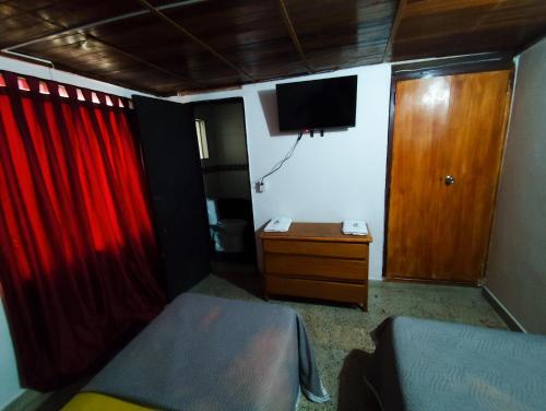 a bedroom with a bed and a tv on the wall at Construyendo Sueños JL in Medellín