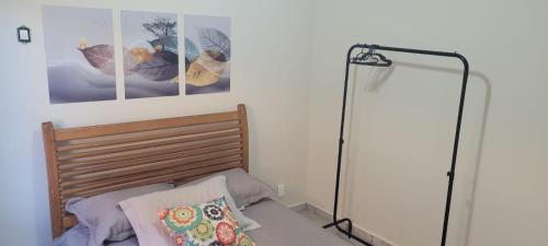 ein Schlafzimmer mit einem Bett mit einer Lampe und Bildern an der Wand in der Unterkunft Recanto do mar e da lagoa in Arraial do Cabo