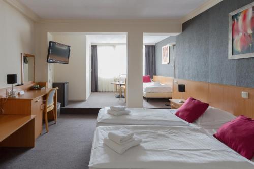ein Hotelzimmer mit 2 Betten und einem TV in der Unterkunft Hotel Restaurant De Baronie in Boxmeer