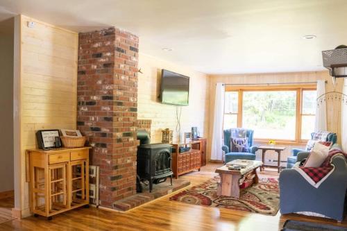 a living room with a brick fireplace and a tv at Cozy Cabin in Stratton Mountain & Mount Snow 10min in Stratton