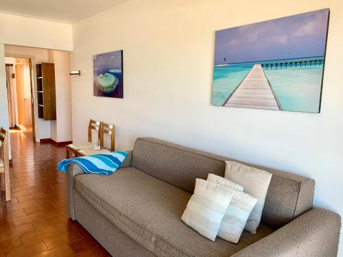 una sala de estar con sofá y una pintura en la pared en Depto Frente Al Mar, Edificio Iskofema II en Miramar