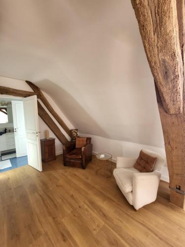 a living room with a couch and a chair at Domaine de charme - Les Places in Lassay-sur-Croisne