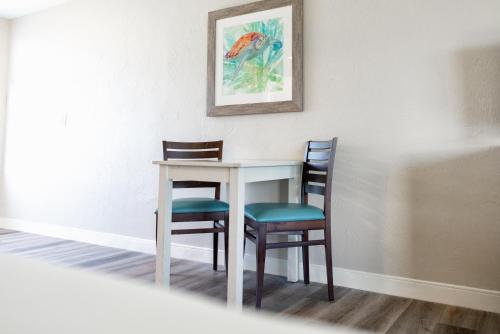 a table and two chairs with a picture on the wall at Perry's Ocean-Edge Resort in Daytona Beach