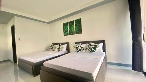 a bedroom with two beds and two windows at Steffen Resort in Dinalupihan