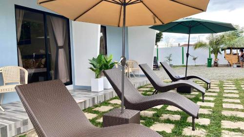 a group of chairs and umbrellas on a patio at Steffen Resort in Dinalupihan