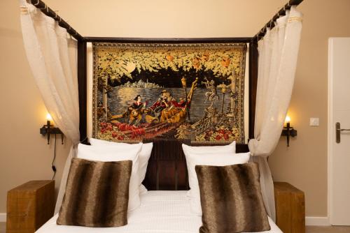 Schlafzimmer mit Wandteppich über einem Bett in der Unterkunft Balda'Quand Médiéval in Carcassonne